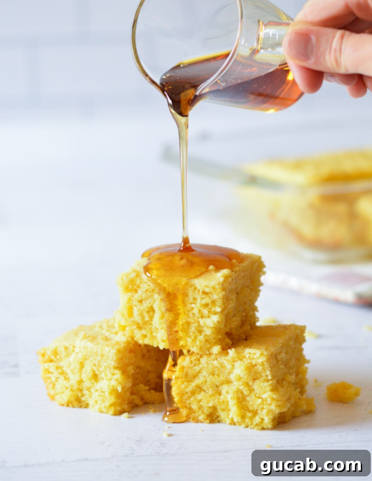 pouring maple syrup onto cornbread. 