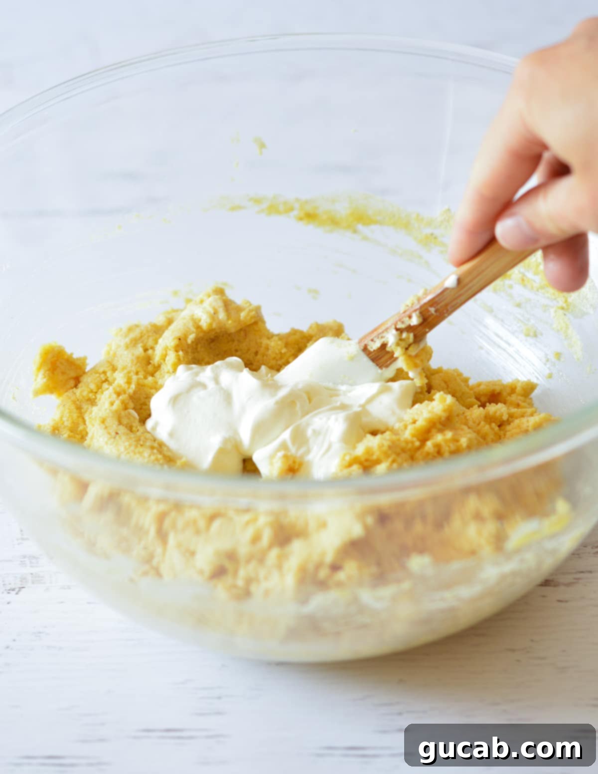 a bowl of cornbread batter with sour cream in it. 