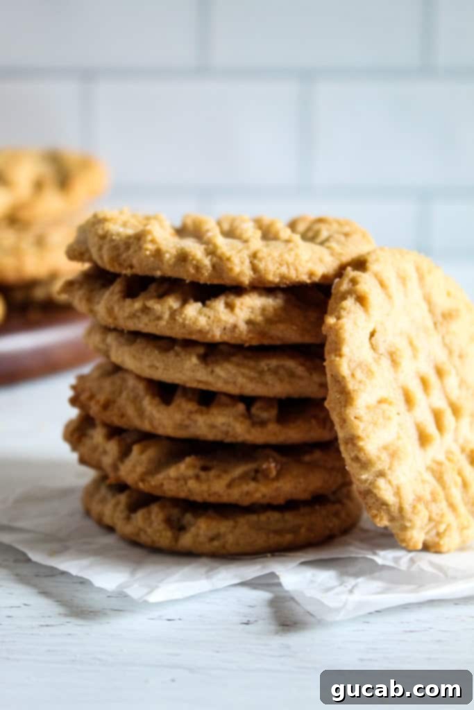 A stack of classic gluten-free peanut butter cookies with criss-cross fork marks.