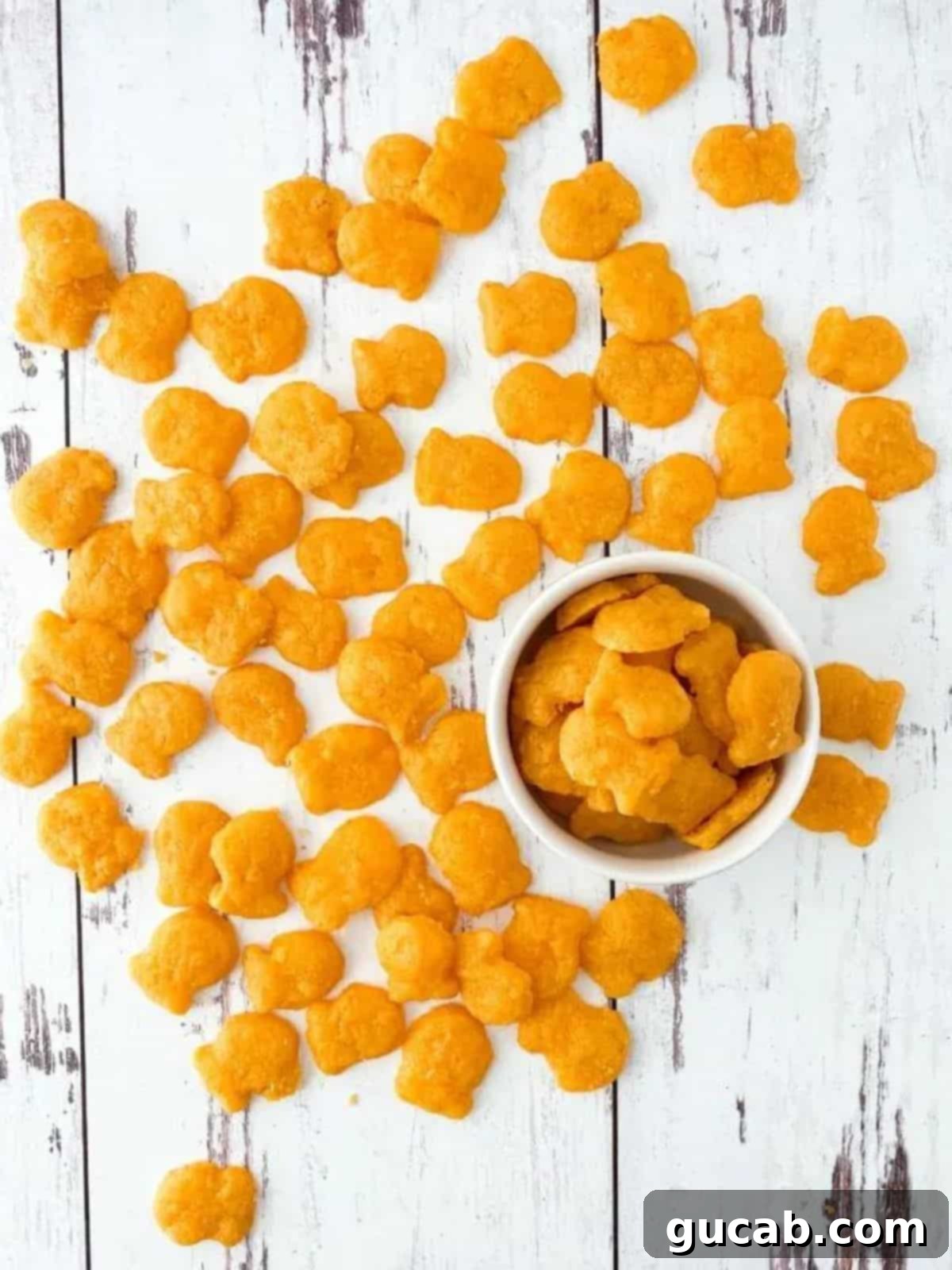 Homemade gluten-free goldfish crackers scattered on a surface.
