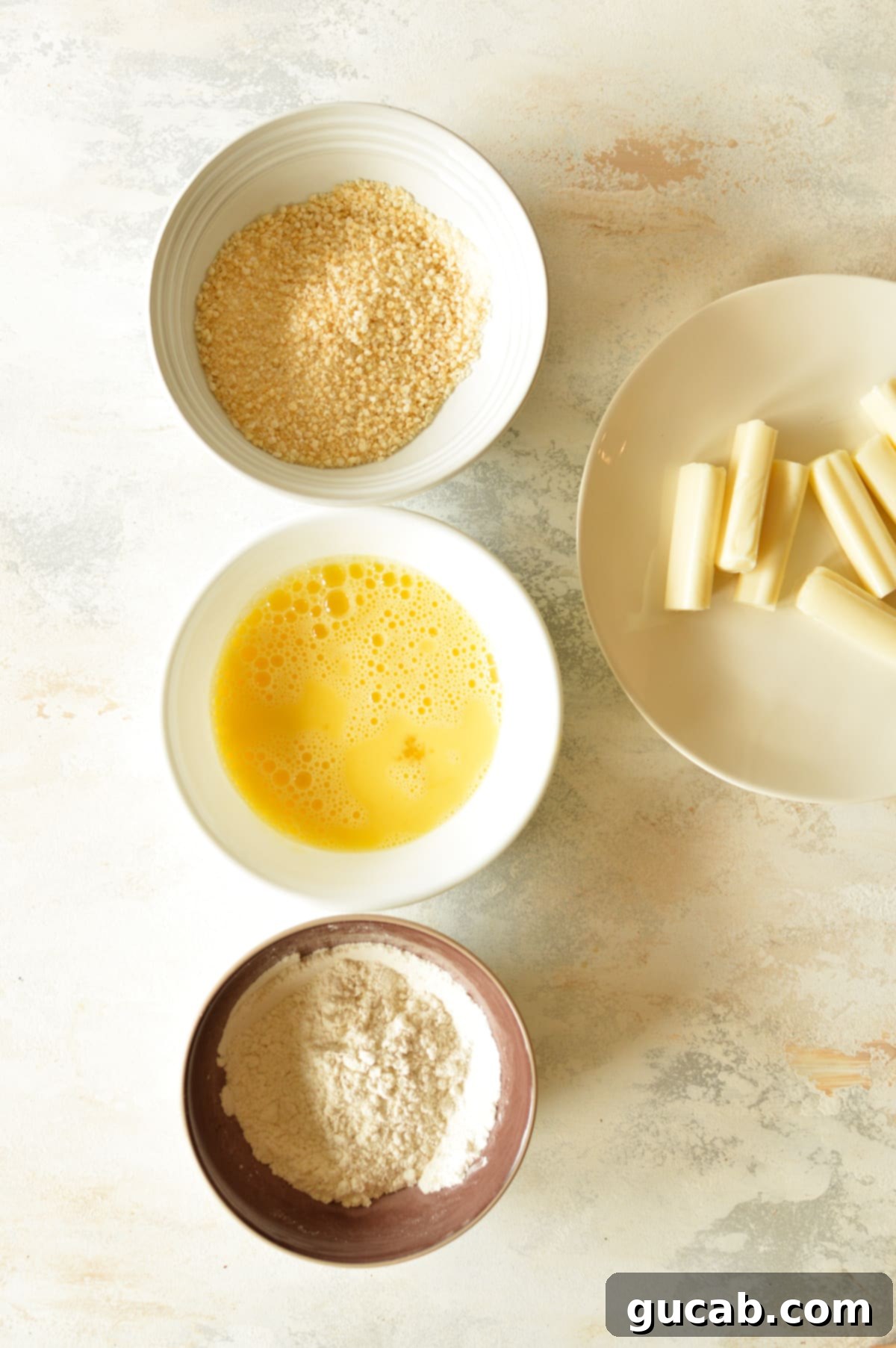 Irresistible Gluten-Free Mozzarella Sticks 4 bowls of gluten free flour, eggs, and breadcrumbs