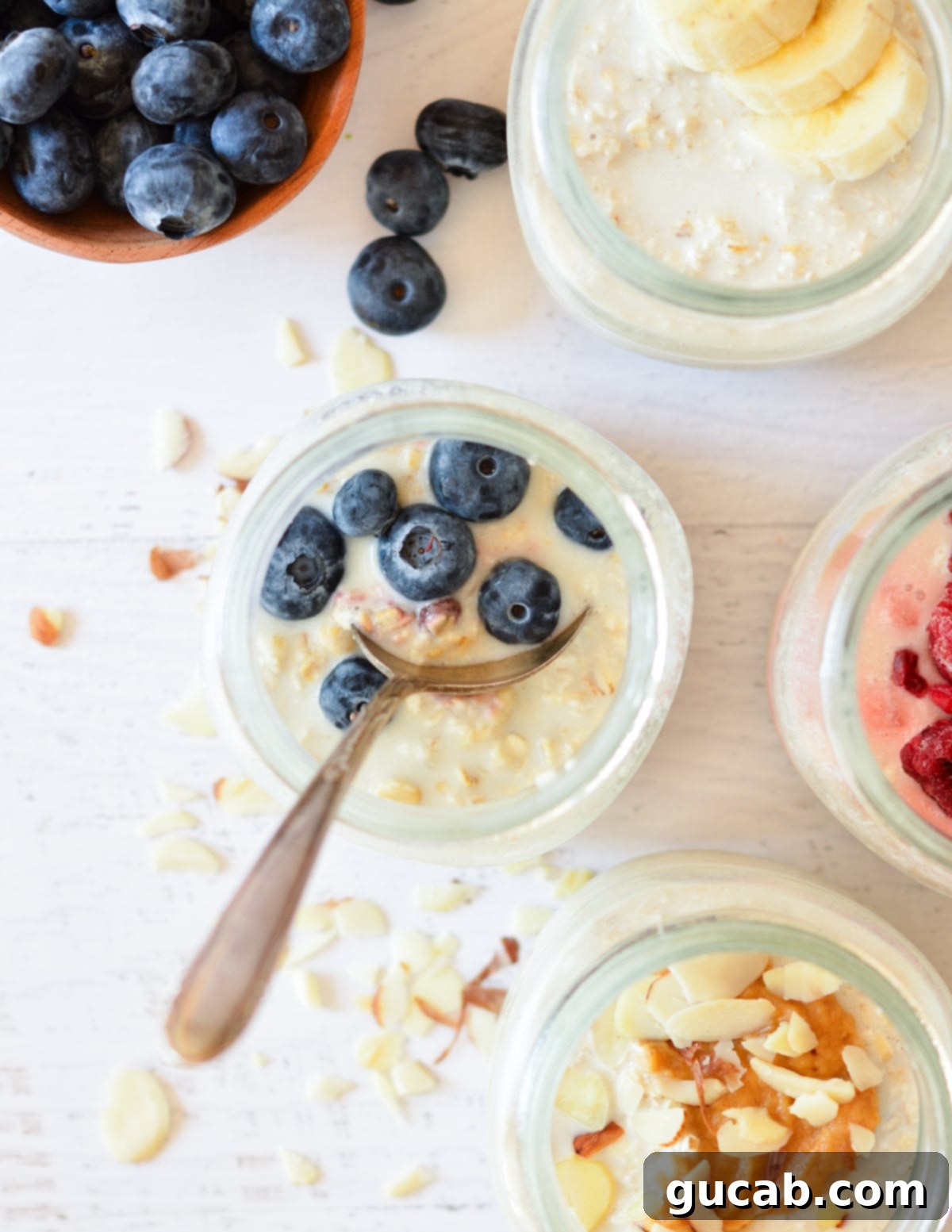 A close-up of a jar of instant overnight oats, perfectly set, topped with fresh blueberries and a spoon resting inside, ready for breakfast.