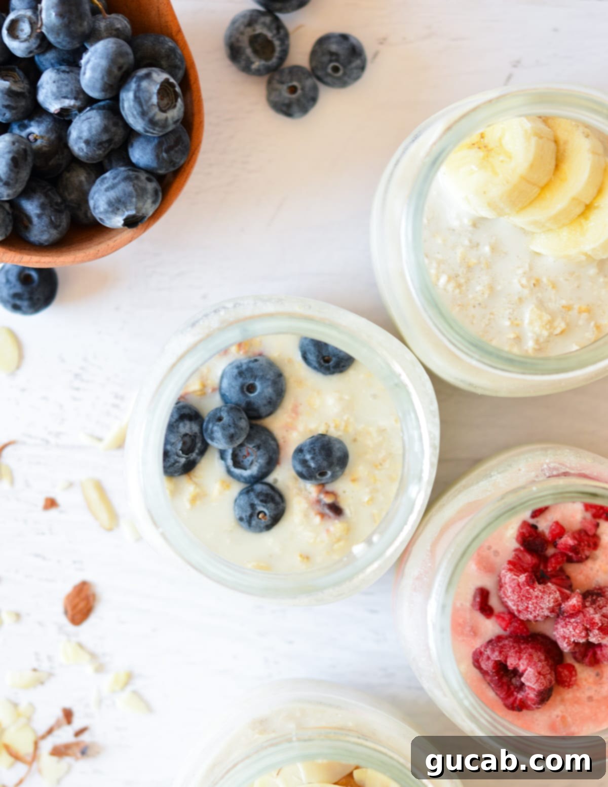 A vibrant display of multiple jars of overnight oats, each topped with a unique combination of fresh fruits like berries and bananas.