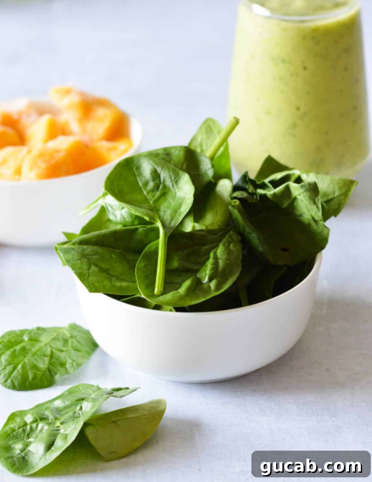 Tropical Green Boost 7 A bowl filled with fresh, vibrant green baby spinach leaves.