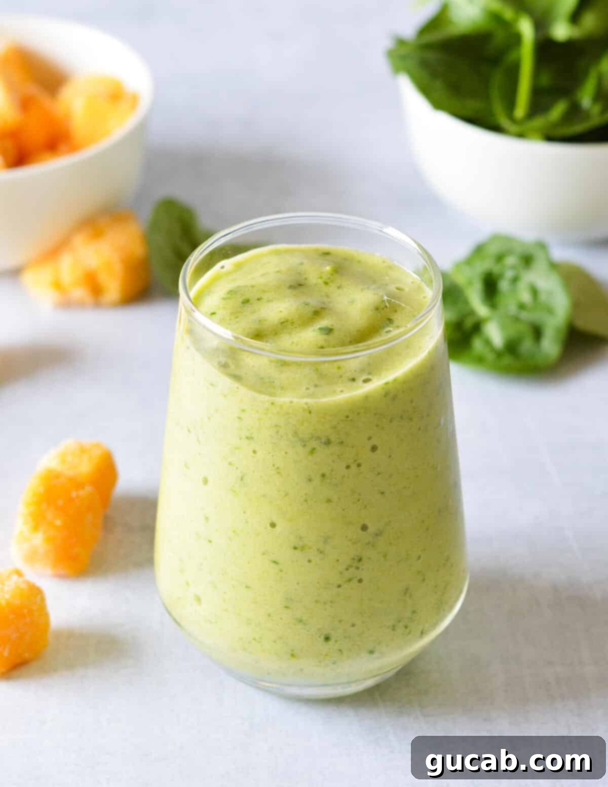 Tropical Green Boost 8 A vibrant green pineapple smoothie in a glass, with a slice of lime on the rim, showcasing its refreshing appeal.