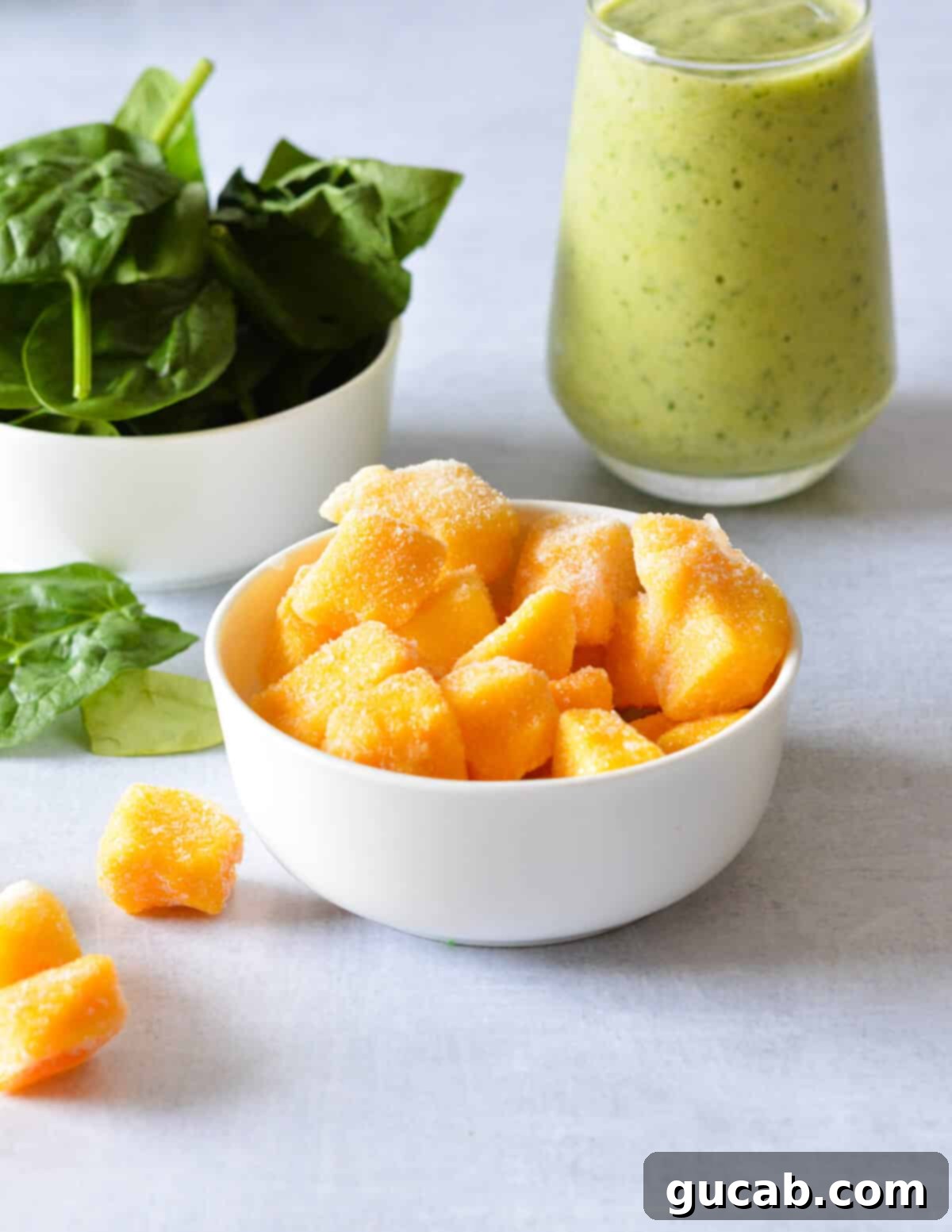 Tropical Green Boost 9 A bowl filled with neatly cut frozen mango chunks, ready for use in a smoothie.