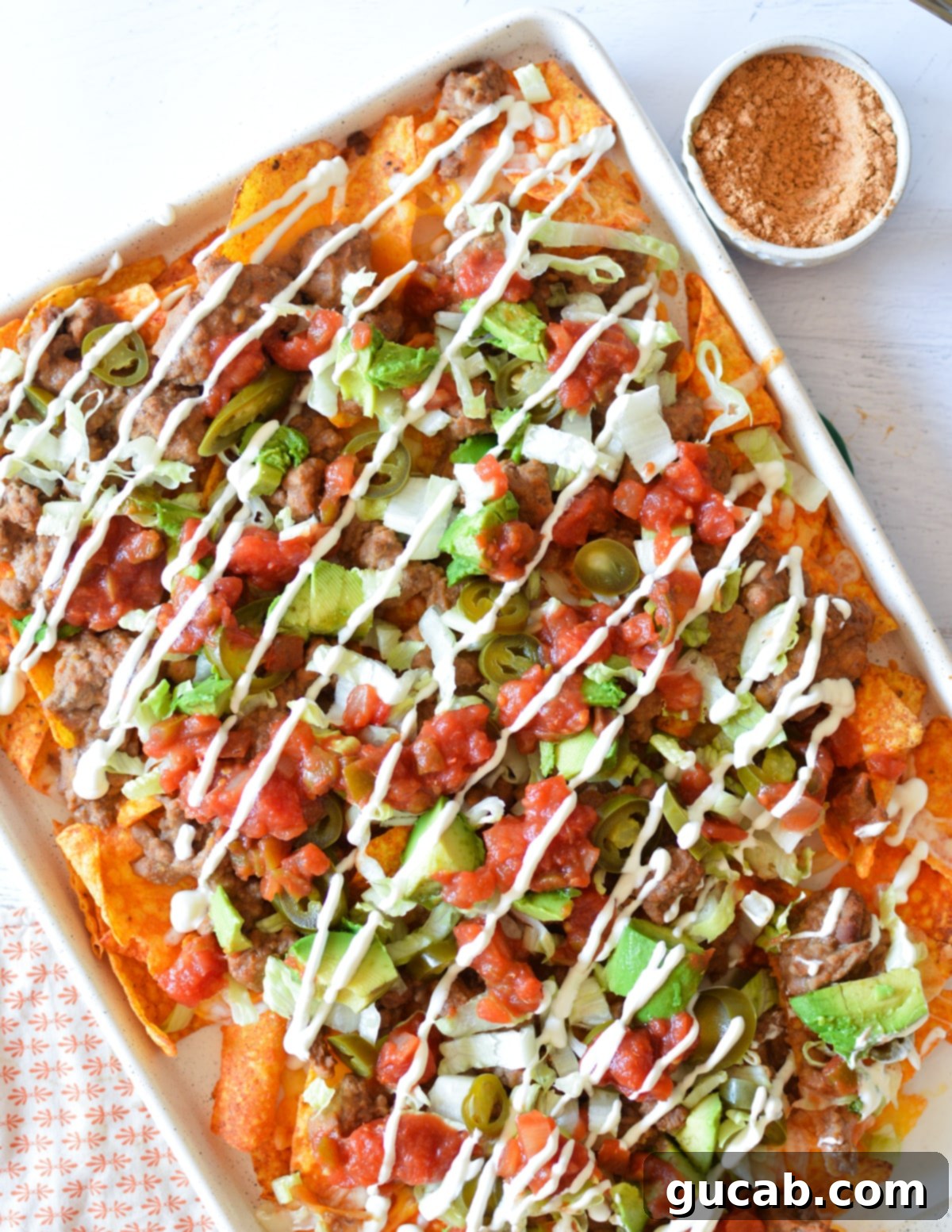 A full sheet pan of generously loaded and baked Doritos nachos, ready to be served.