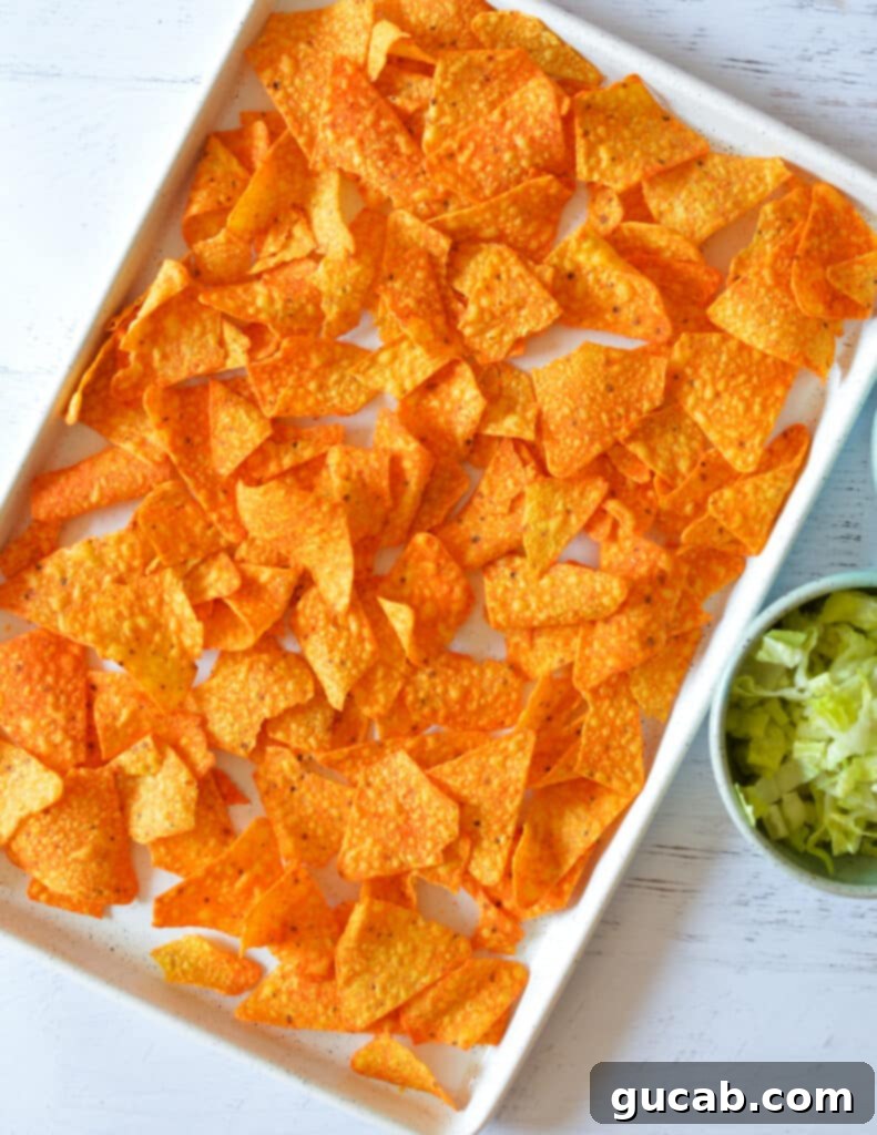 A sheet pan lined with parchment paper, covered with an even layer of Doritos chips.