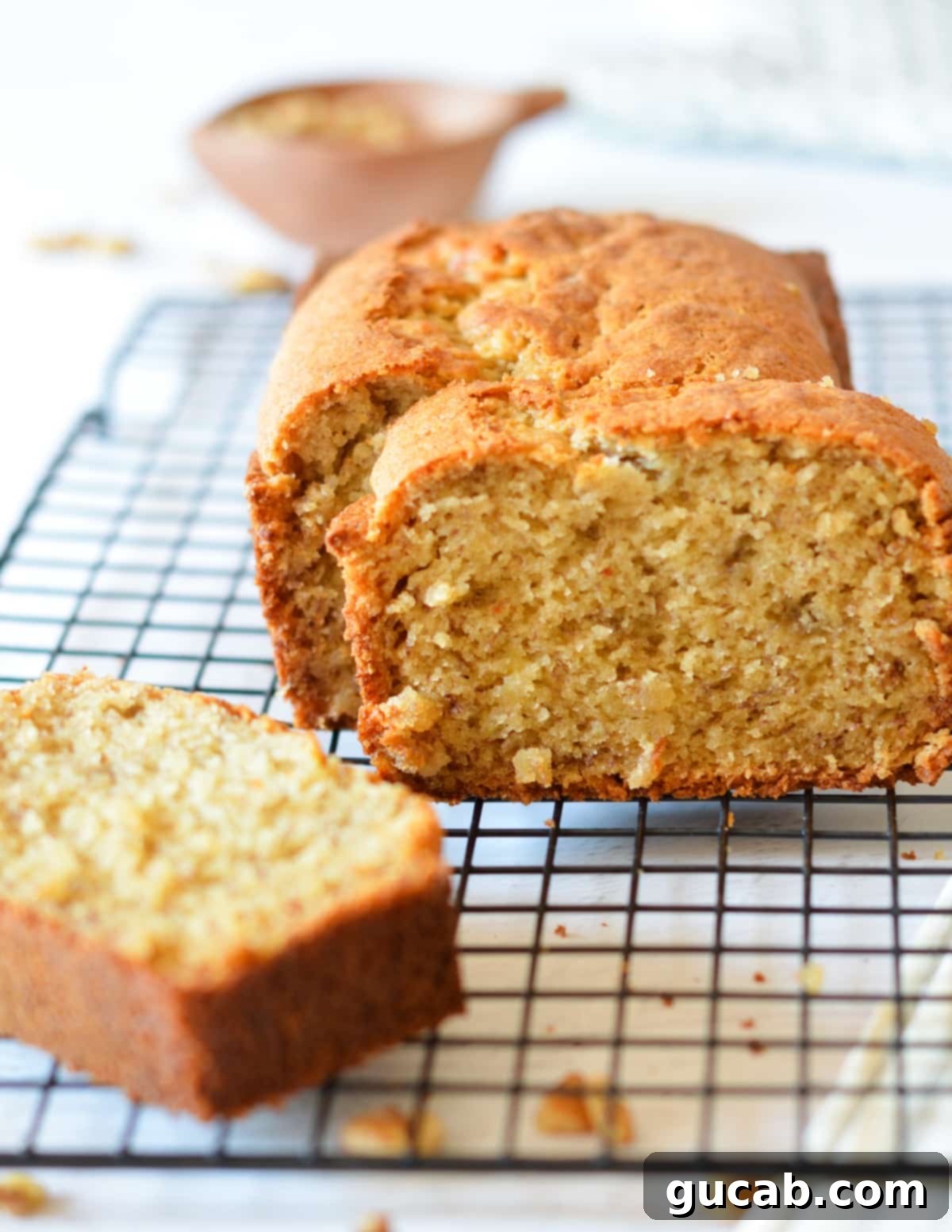 The Key to Amazing Banana Bread Frozen Bananas 13 A perfectly baked, thick slice of banana bread sitting upright, showcasing its moist texture and golden crust.