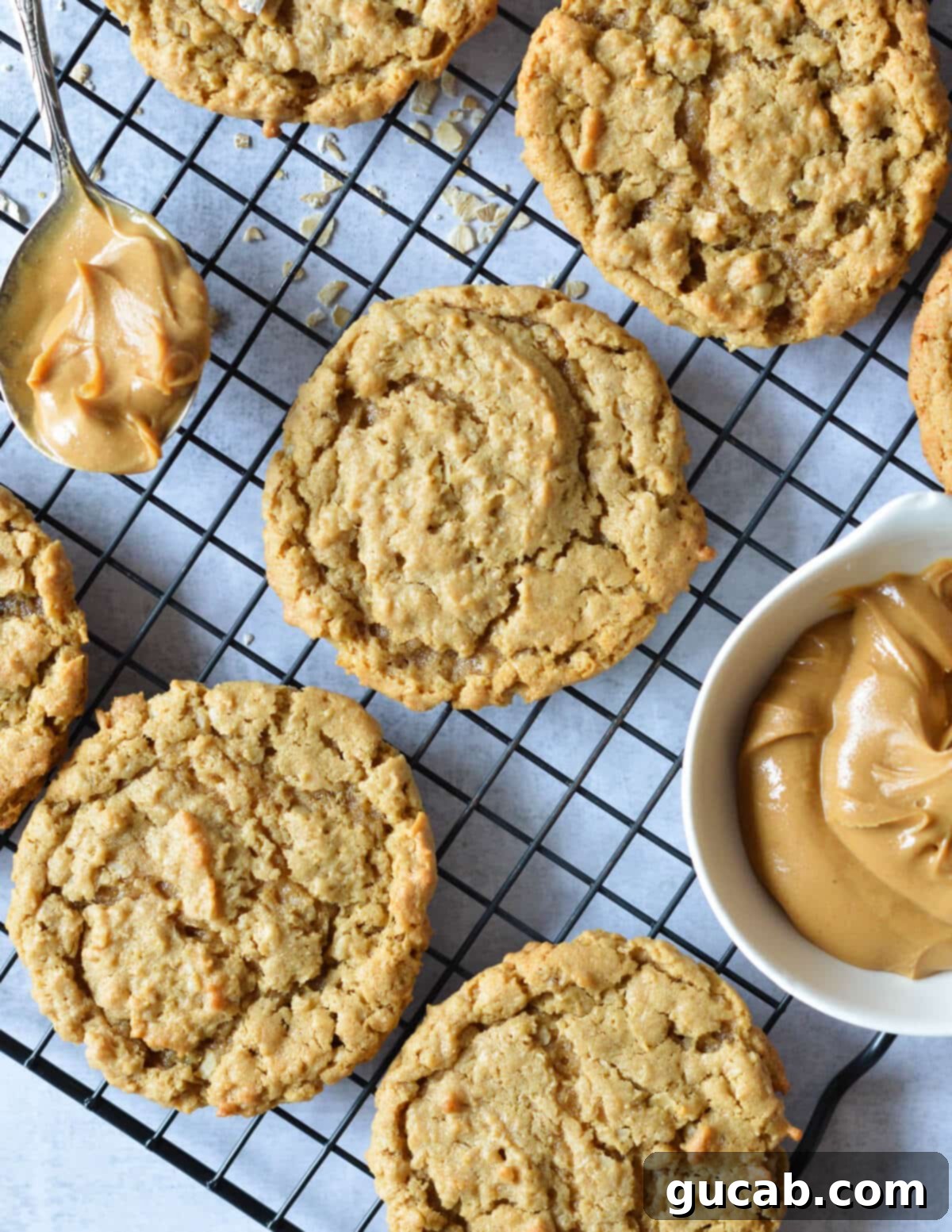 peanut butter cookies on a wire rack near a bowl of peanut butter. 