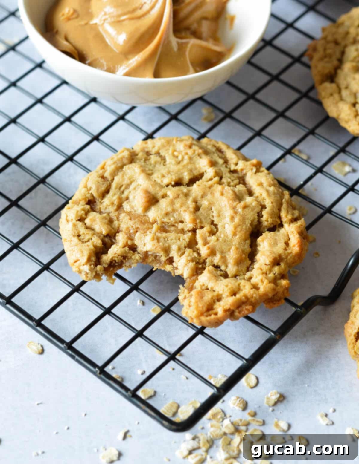 a peanut butter cookie with a bite out of it on a cooling rack. 