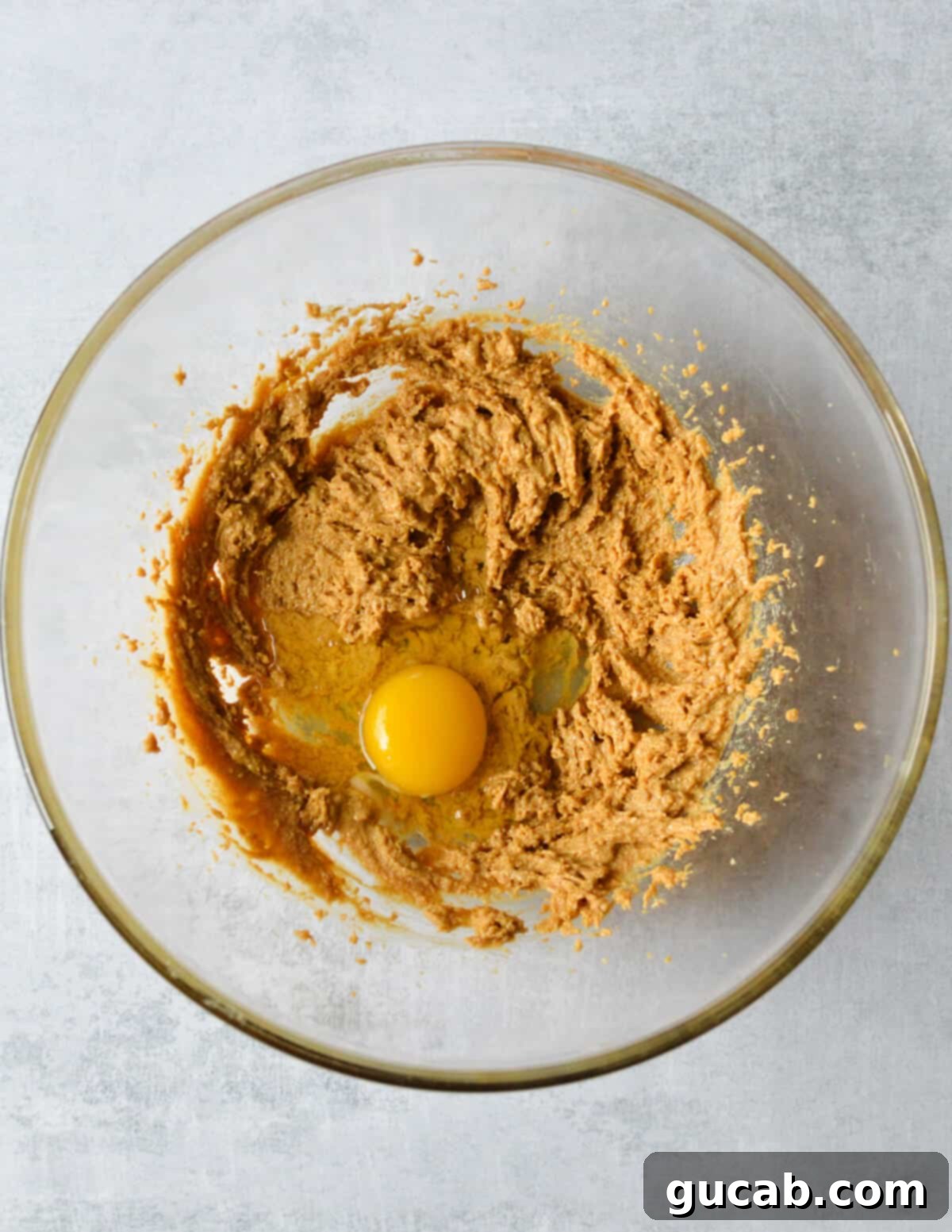 whipped peanut butter and sugar with an egg on top in a bowl.