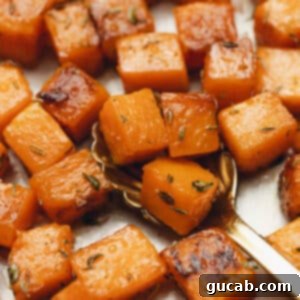 Close up of perfectly sauteed butternut squash cubes with a maple-butter glaze and dried thyme.