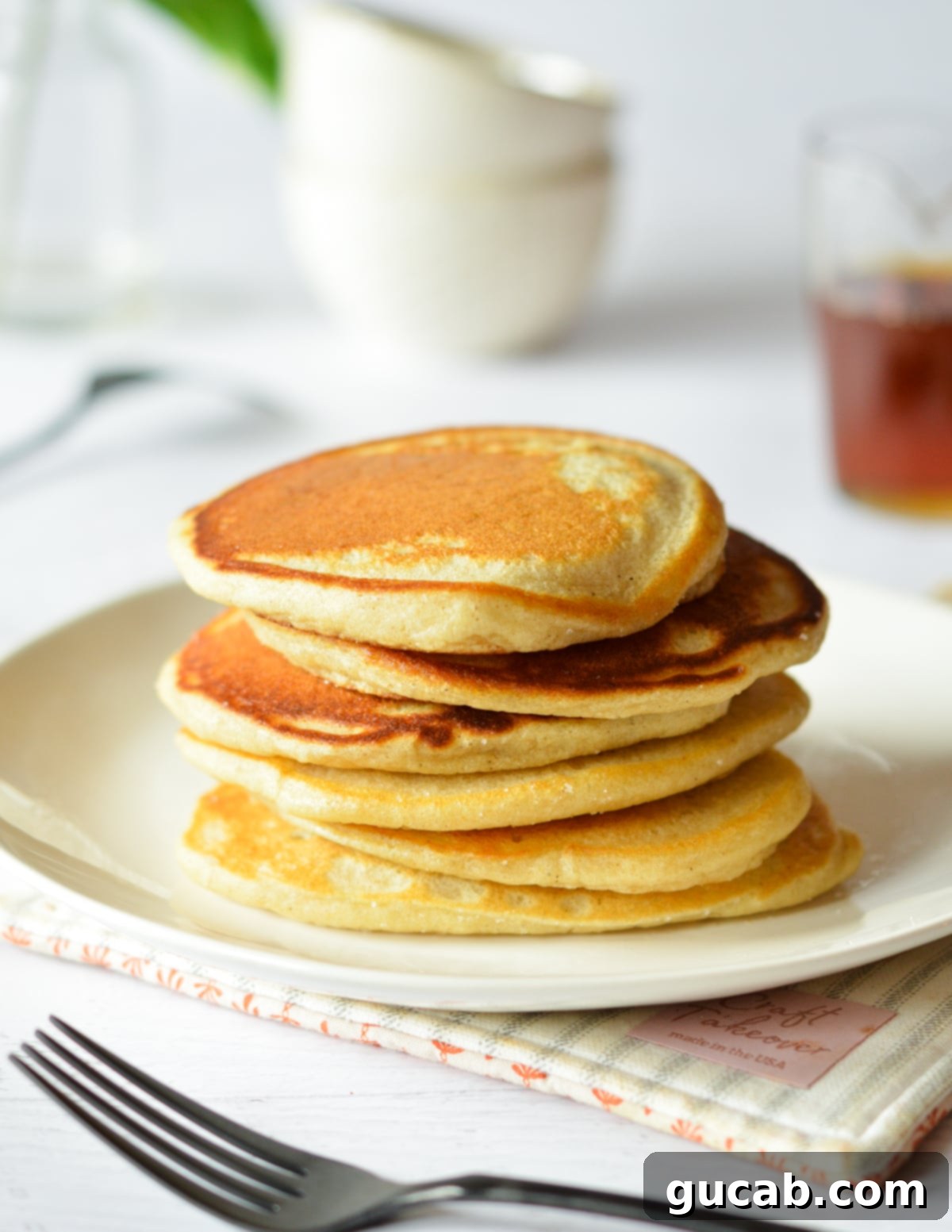 A perfectly stacked pile of thin, golden-brown pancakes, highlighting their crispy texture.