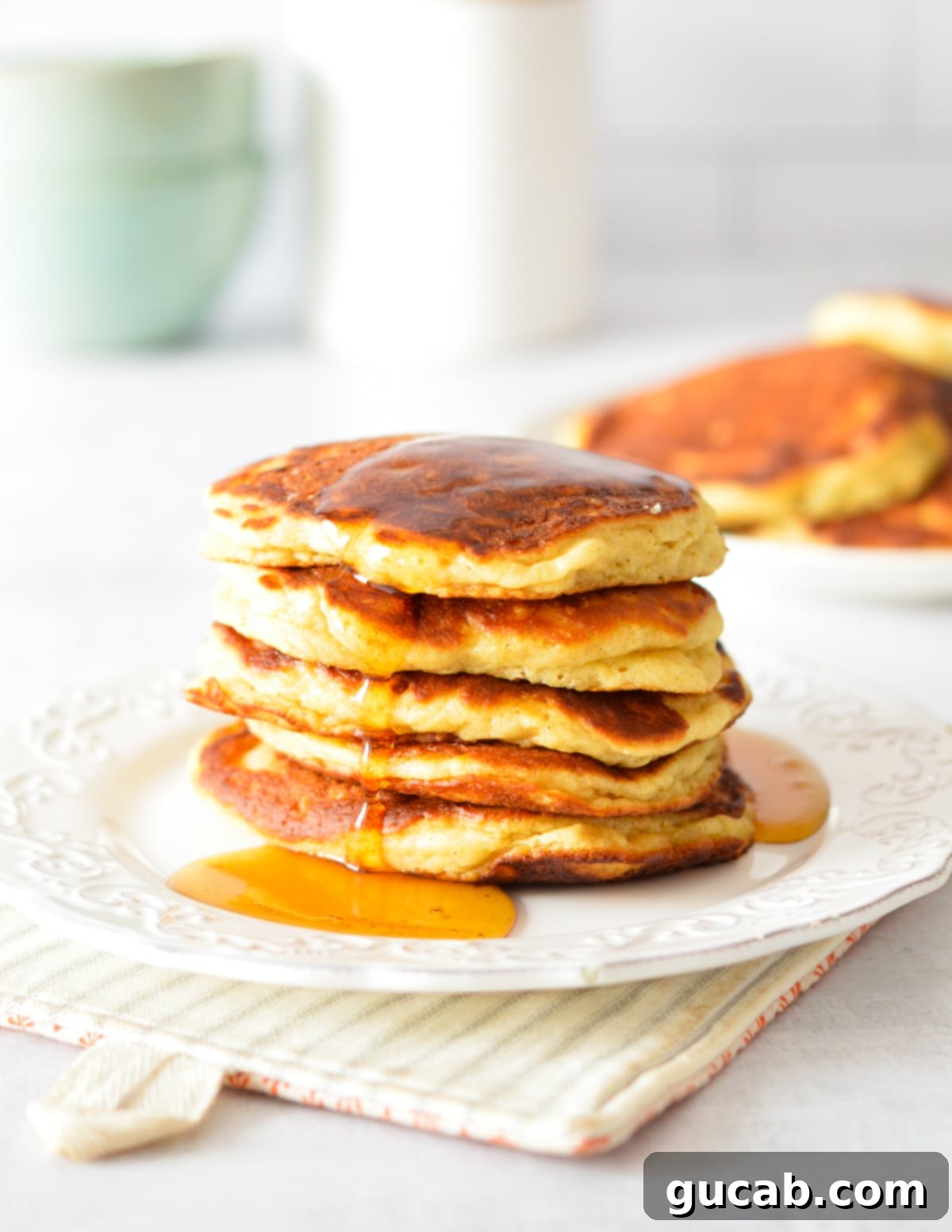 Fluffy Honey Pancakes 12 a stack of pancakes with maple syrup dripping down them.