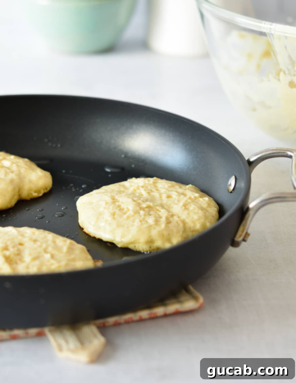 Fluffy Honey Pancakes 8 pancake batter in a skillet.