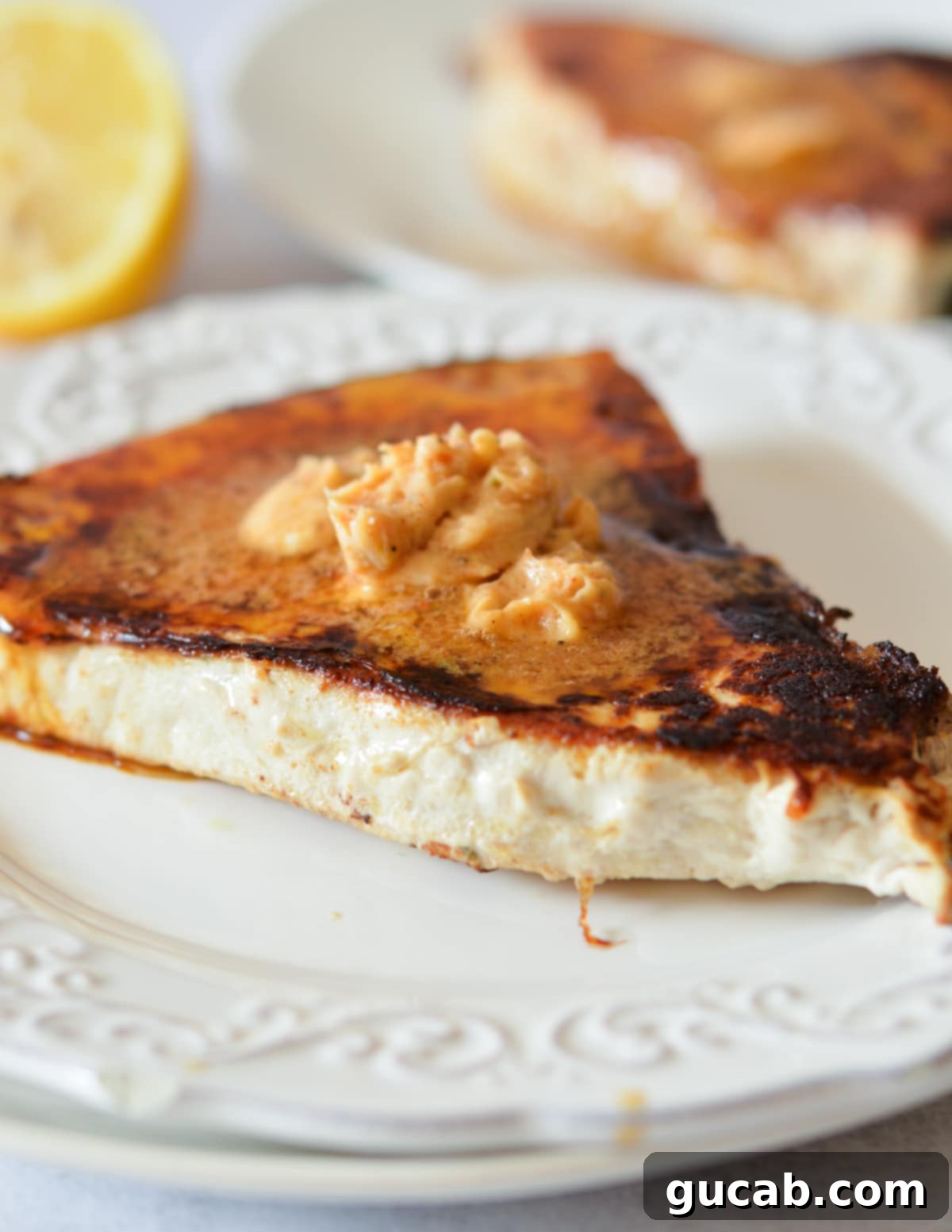 Blackened swordfish with Cajun butter melting on top, garnished with fresh herbs.