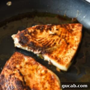 blackened swordfish in a skillet.