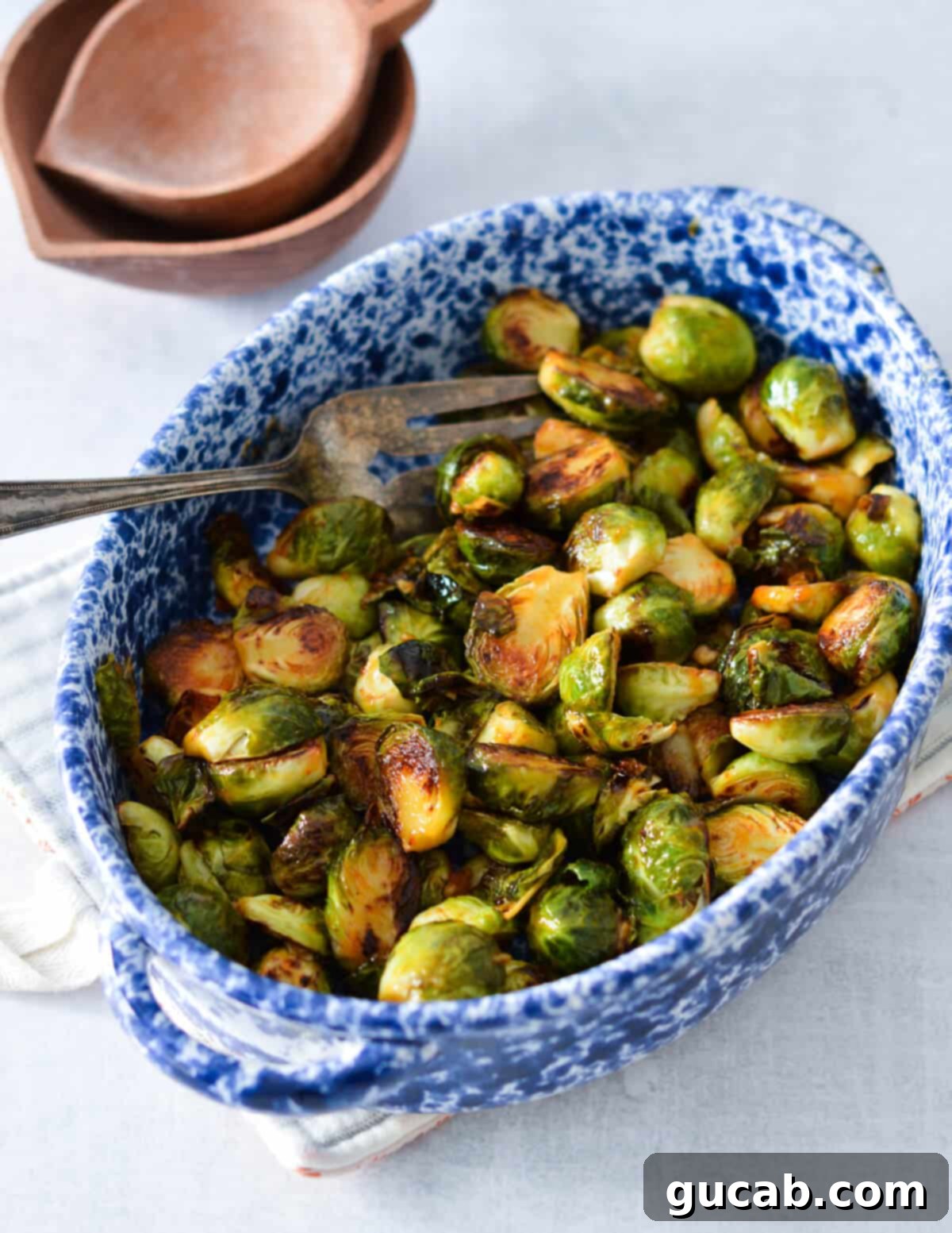 A vibrant dish of golden-brown honey sriracha brussels sprouts, garnished and ready to serve.