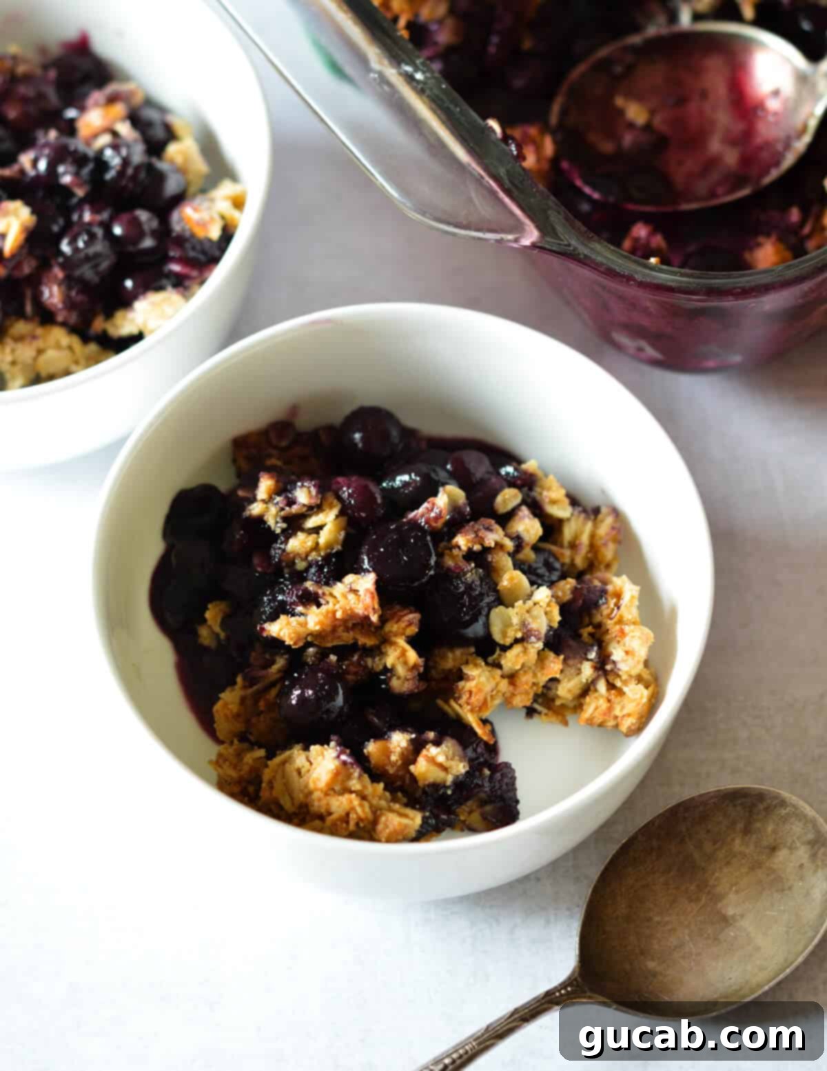 A bowl of healthy blueberry crisp, steaming slightly, ready to be served.