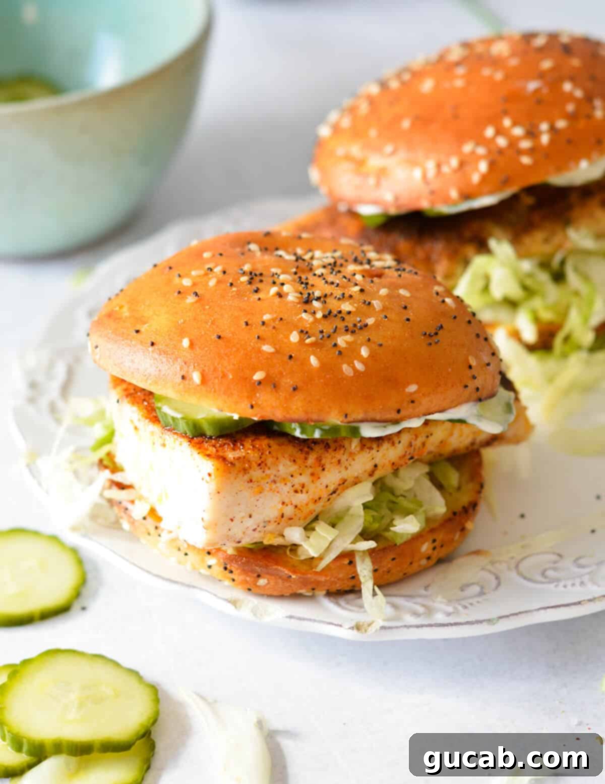Two perfectly assembled mahi mahi sandwiches resting on a plate, ready to be served.