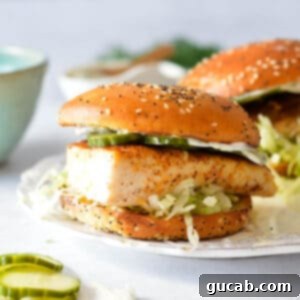 A delicious blackened mahi mahi sandwich with crisp pickles and creamy lemon aioli on a brioche bun.