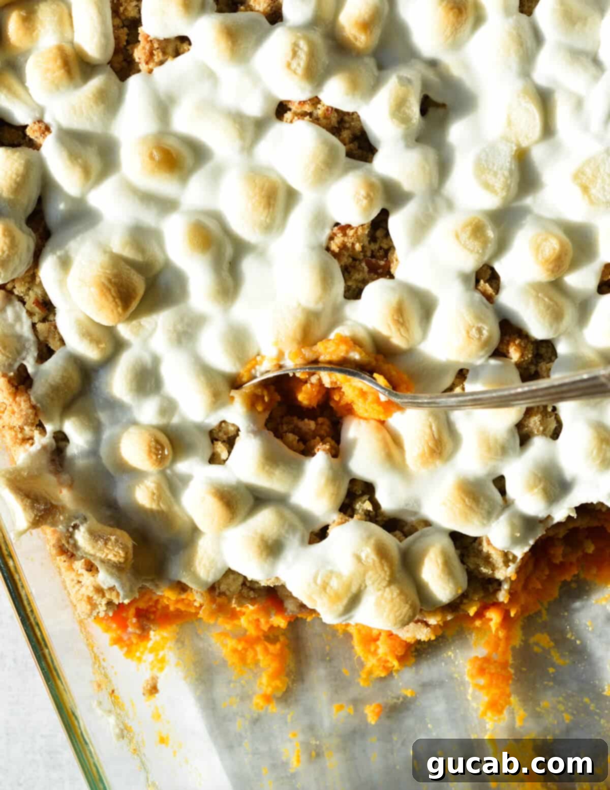 Heavenly Sweet Potato Casserole 2 A spoonful of classic sweet potato casserole with a golden, toasted marshmallow topping, ready to be enjoyed.