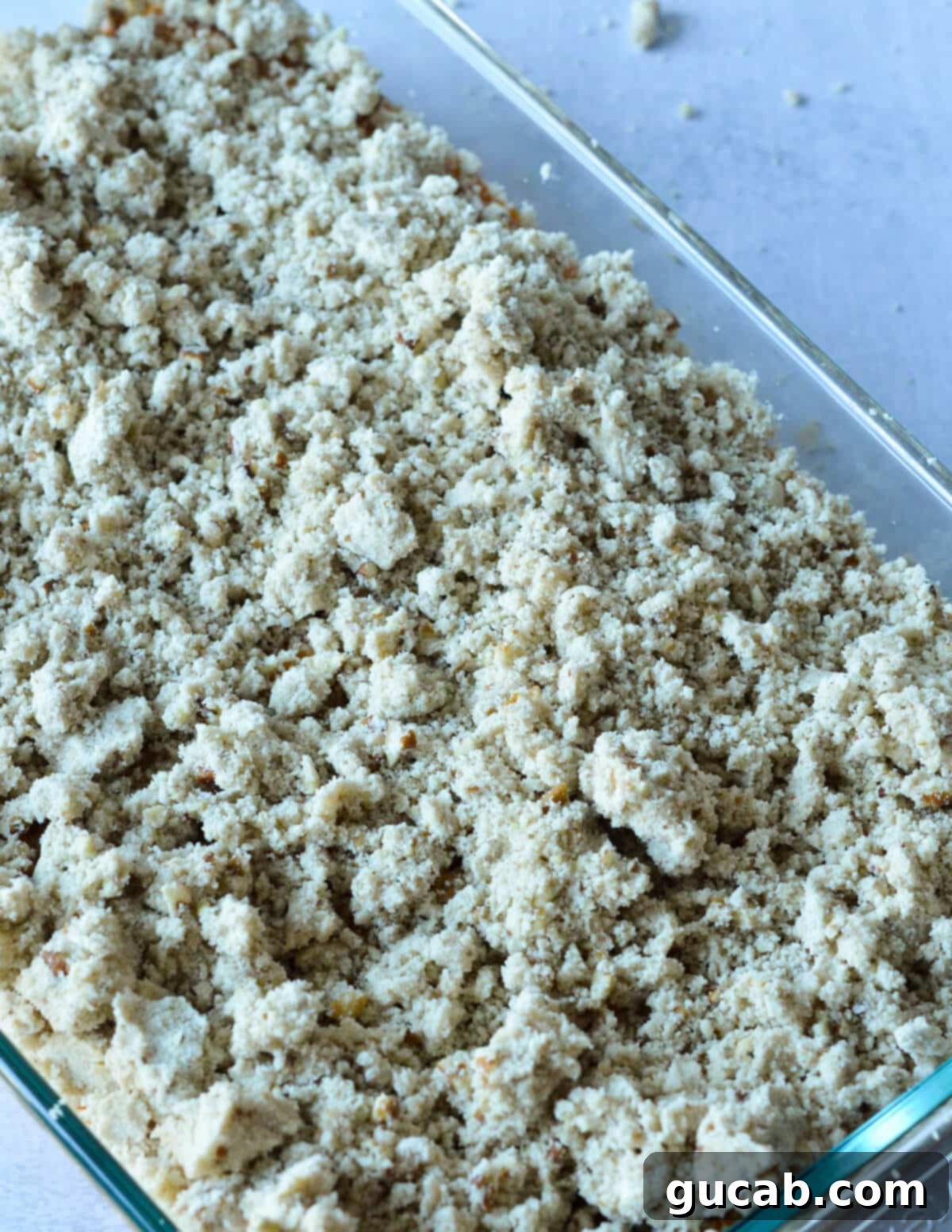 Heavenly Sweet Potato Casserole 13 An unbaked sweet potato casserole in a dish, topped with the pecan crumble.