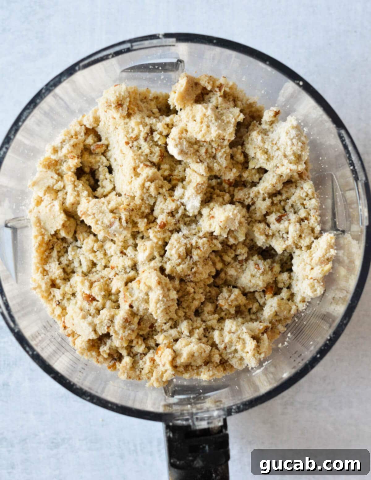 Heavenly Sweet Potato Casserole 9 The finished buttery pecan crumble topping in a food processor, appearing sandy and clumpy.
