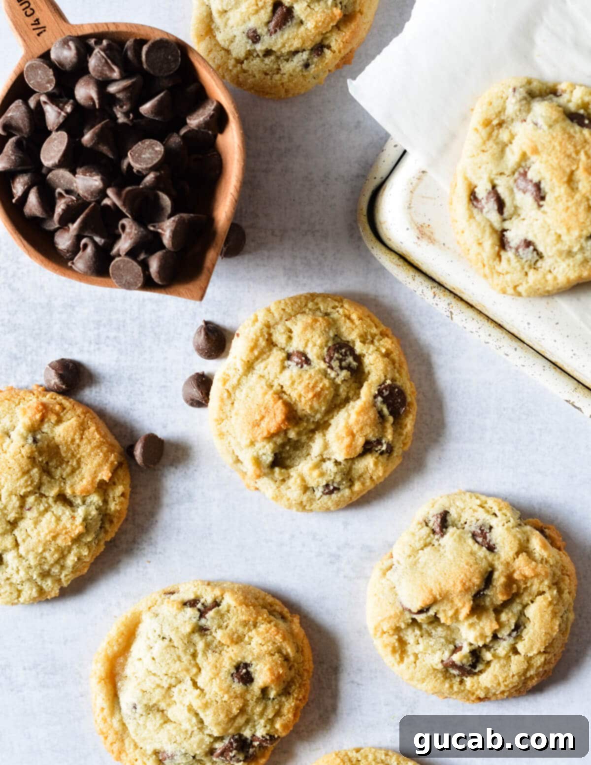 almond flour chocolate chip cookies near a cup of chocolate chips. 