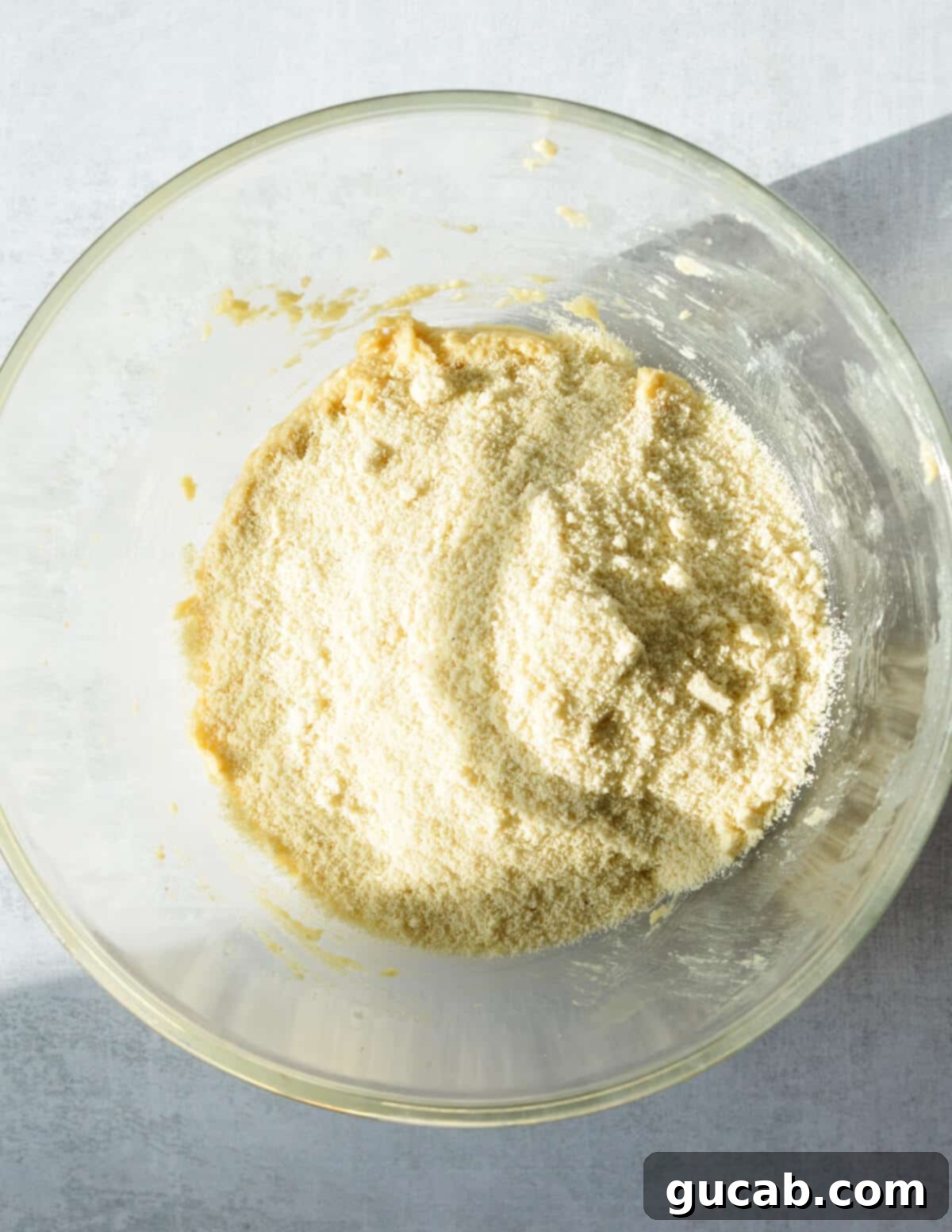 a bowl of creamed butter and sugar with almond flour on top.