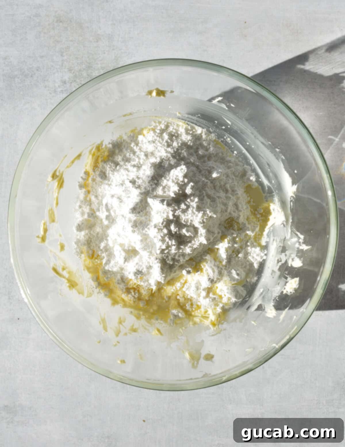 a bowl of whipped butter with powdered sugar and heavy cream on top.