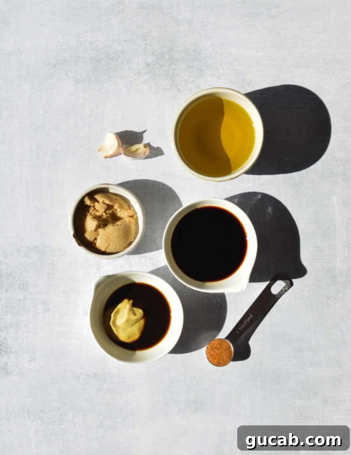 A colorful array of key marinade ingredients thoughtfully arranged on a clean kitchen counter: golden olive oil, minced fresh garlic, rich balsamic vinegar, sweet brown sugar, tangy Dijon mustard, savory Worcestershire sauce, and a sprinkle of seasoned salt.
