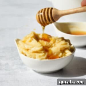 A charming close-up of honey butter in a small dish, with a fresh drizzle of honey on top, emphasizing its rich texture and sweet appeal.