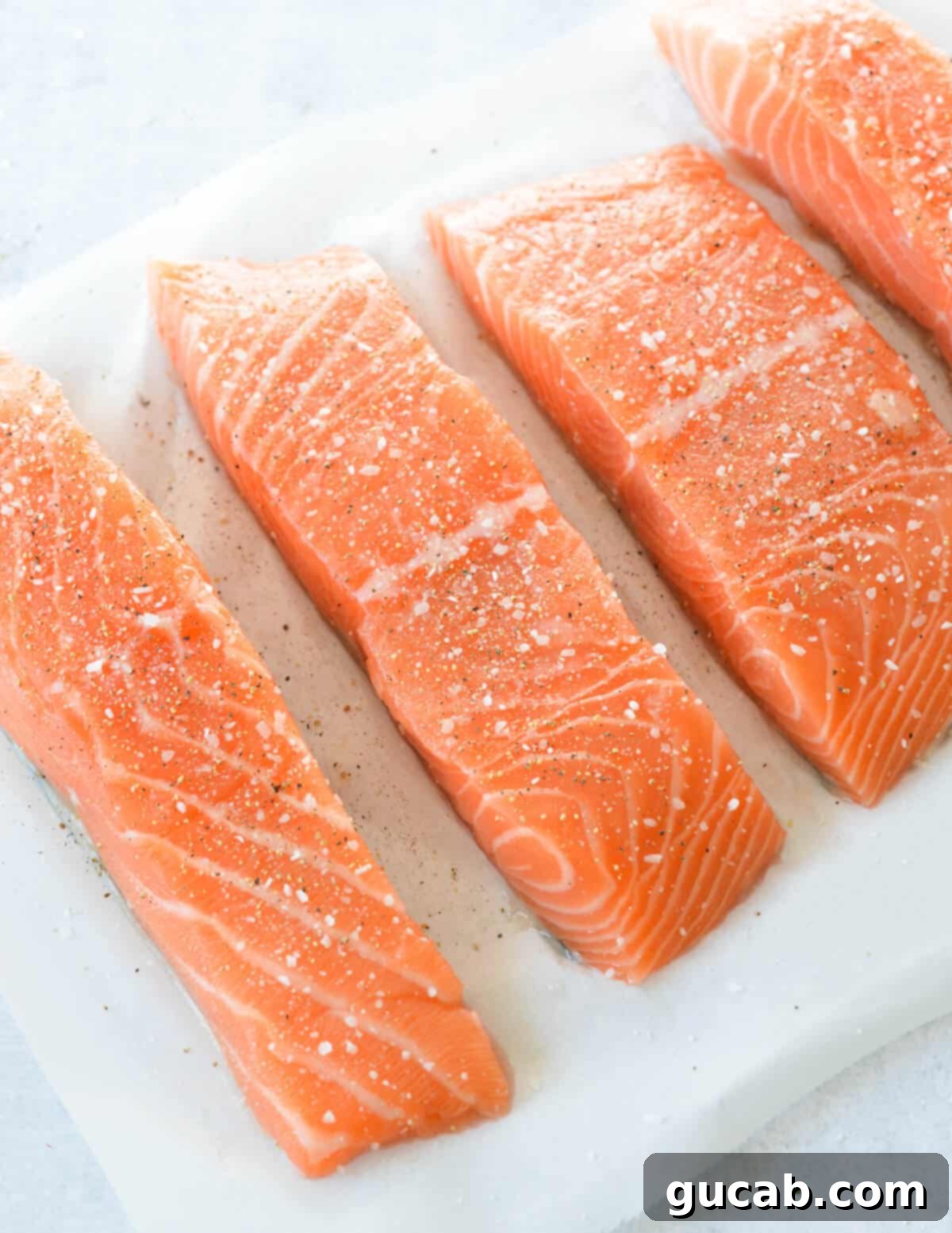 seasoned salmon fillets on parchment paper. 