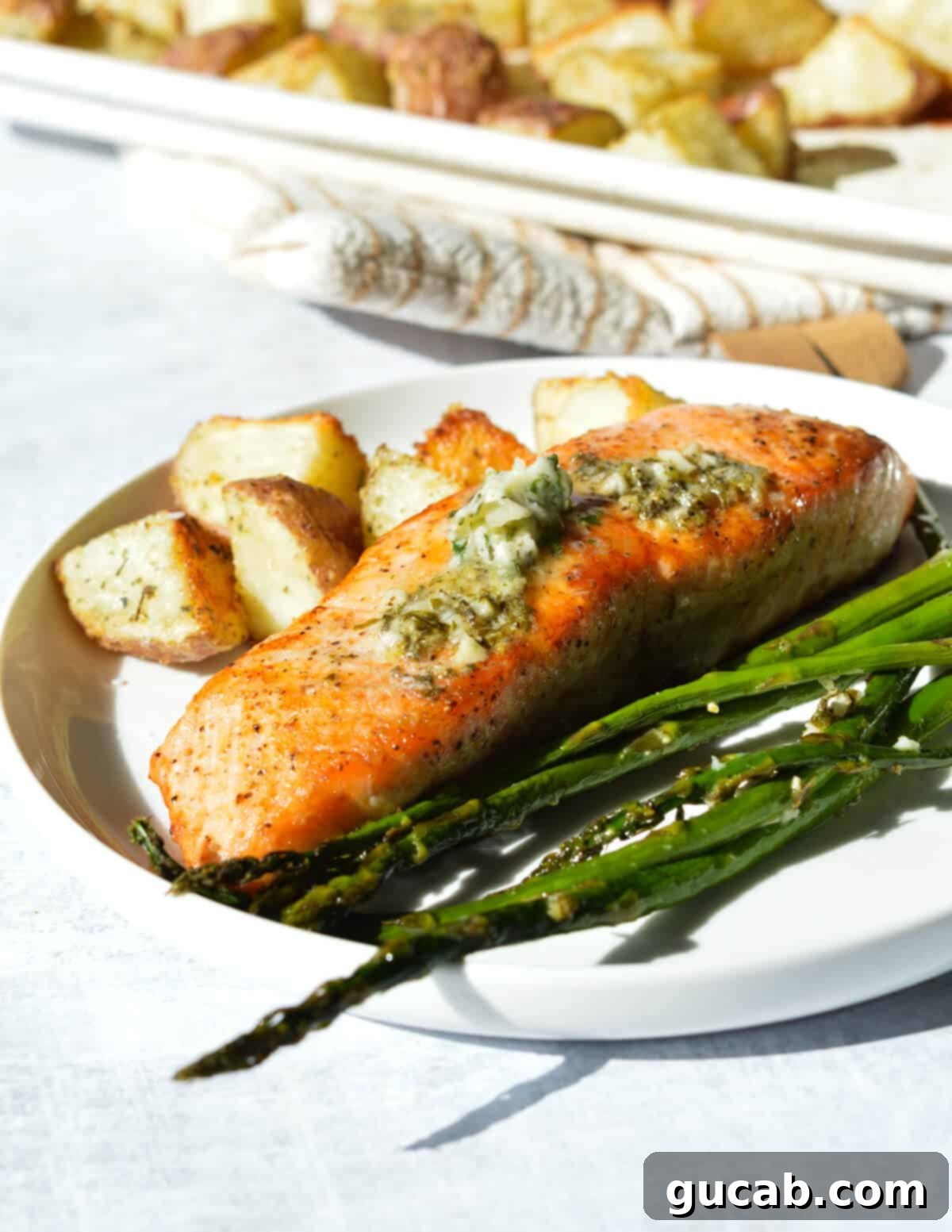 roasted salmon with herb butter, roasted asparagus, and roasted potatoes on a plate, 