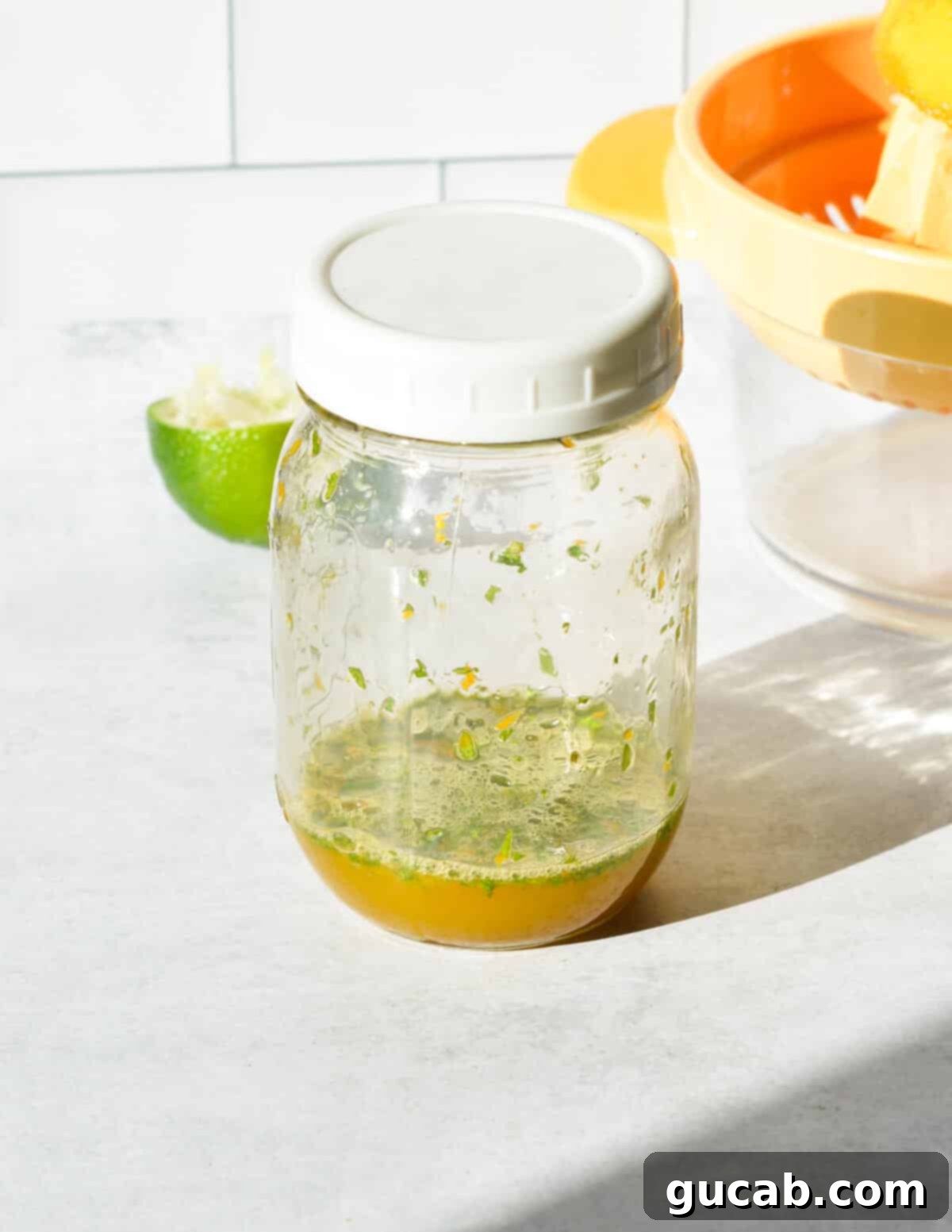 A mason jar with a label indicating 'Citrus Mint Dressing', showing the perfectly mixed and combined dressing ingredients.