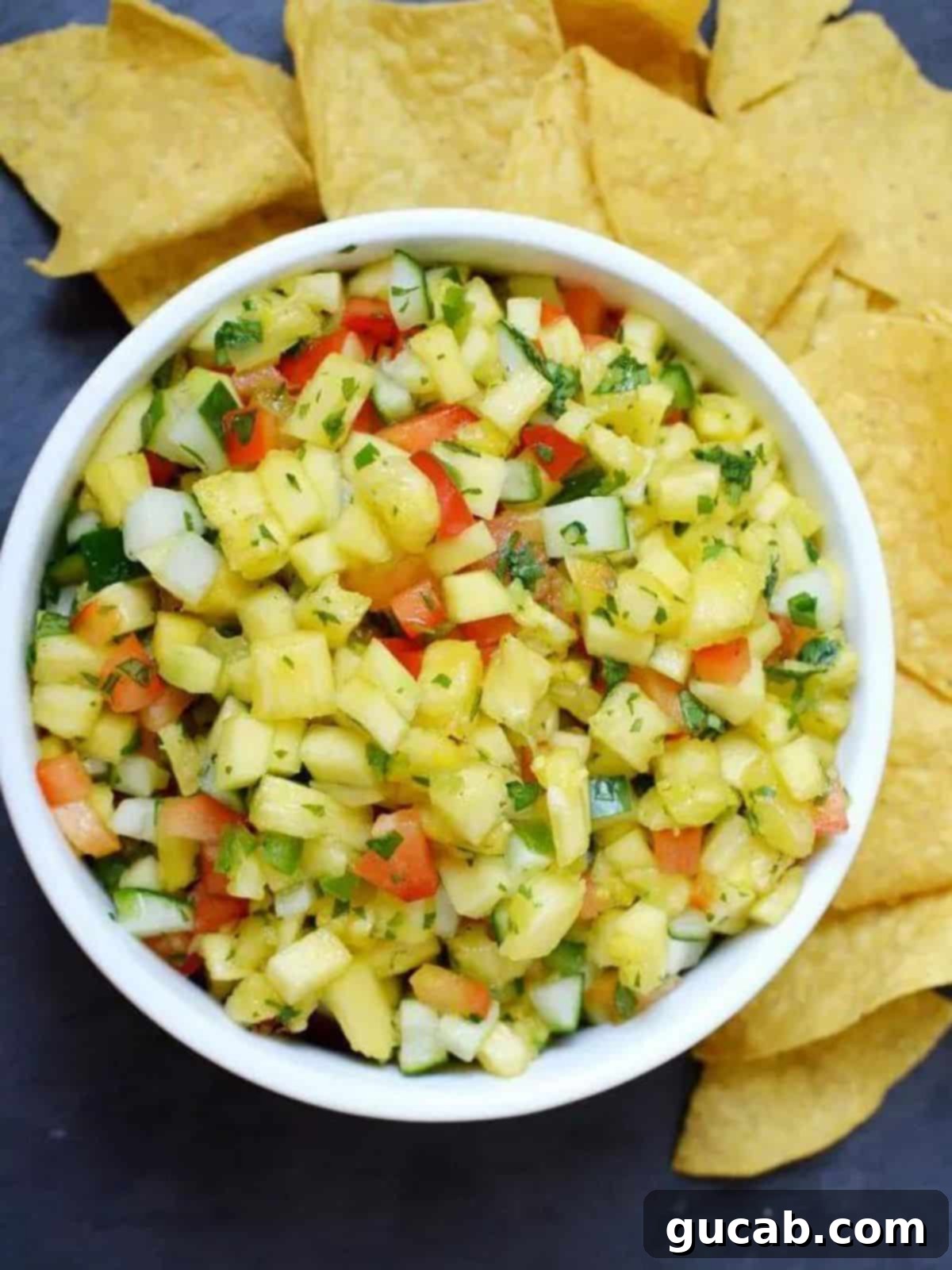 Sun-Kissed Mango Creations 2 A large bowl of vibrant pineapple mango salsa with crispy tortilla chips.