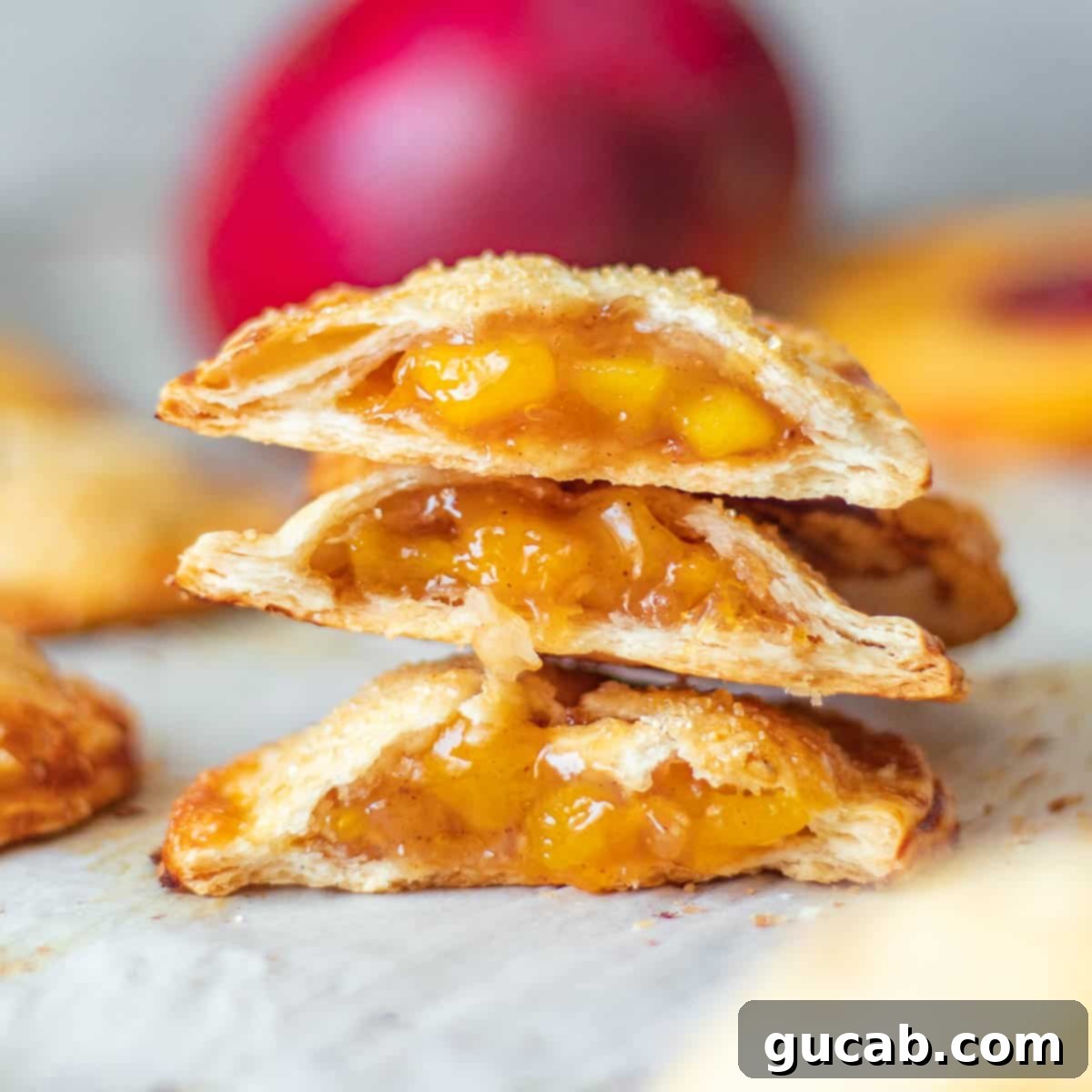 Sun-Kissed Mango Creations 4 A stack of golden brown peach mango hand pies with flaky crusts.