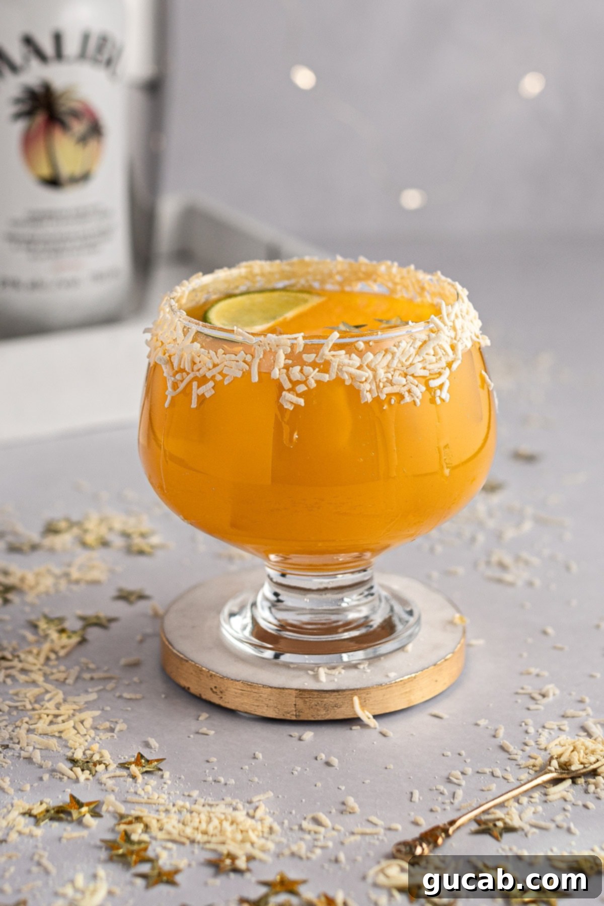 Sun-Kissed Mango Creations 6 A vibrant tropical mango tango cocktail in a glass with lime garnish.