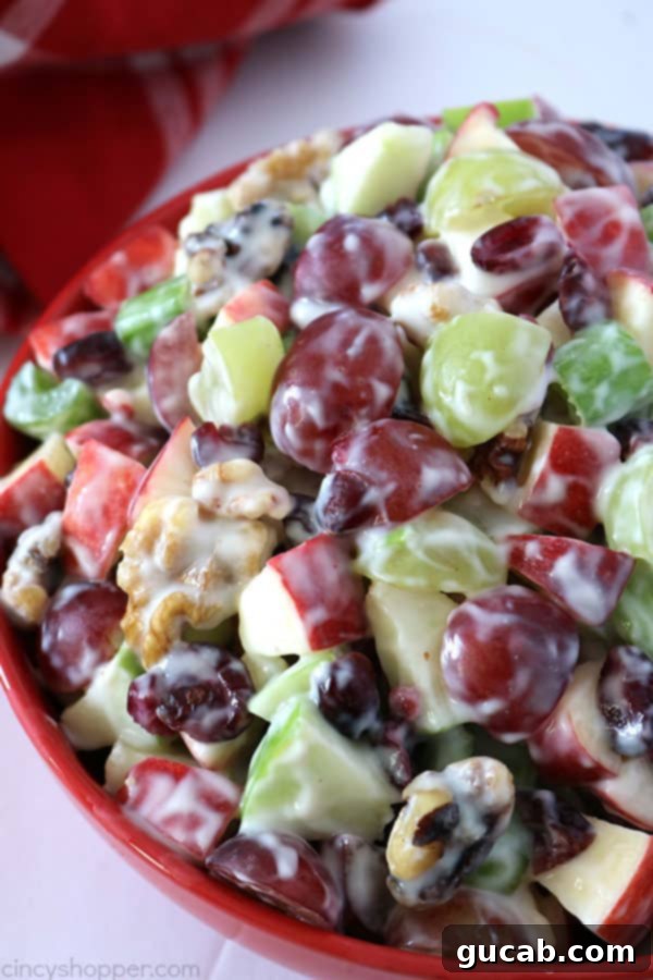 A classic Waldorf salad, vibrant with crisp apples, juicy grapes, crunchy walnuts, and creamy dressing, presented in an elegant bowl.