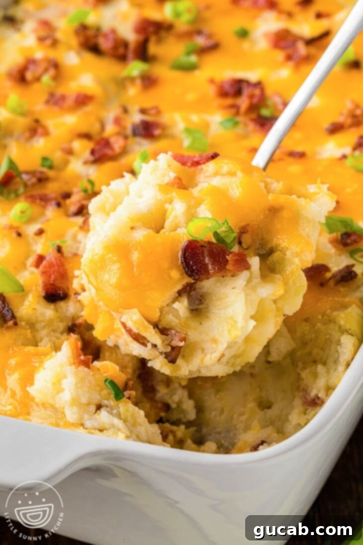 A hearty spoonful of creamy twice-baked potato casserole, generously loaded with melted cheese and crispy bacon bits.