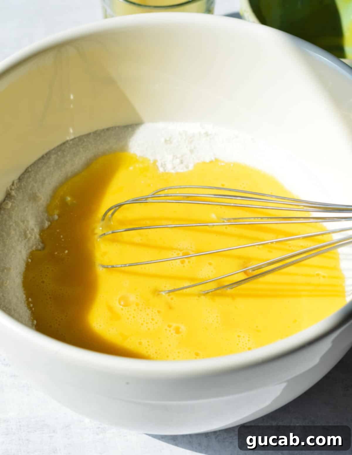 A bowl of sugar with several eggs, being whisked together for the lemon bar filling.