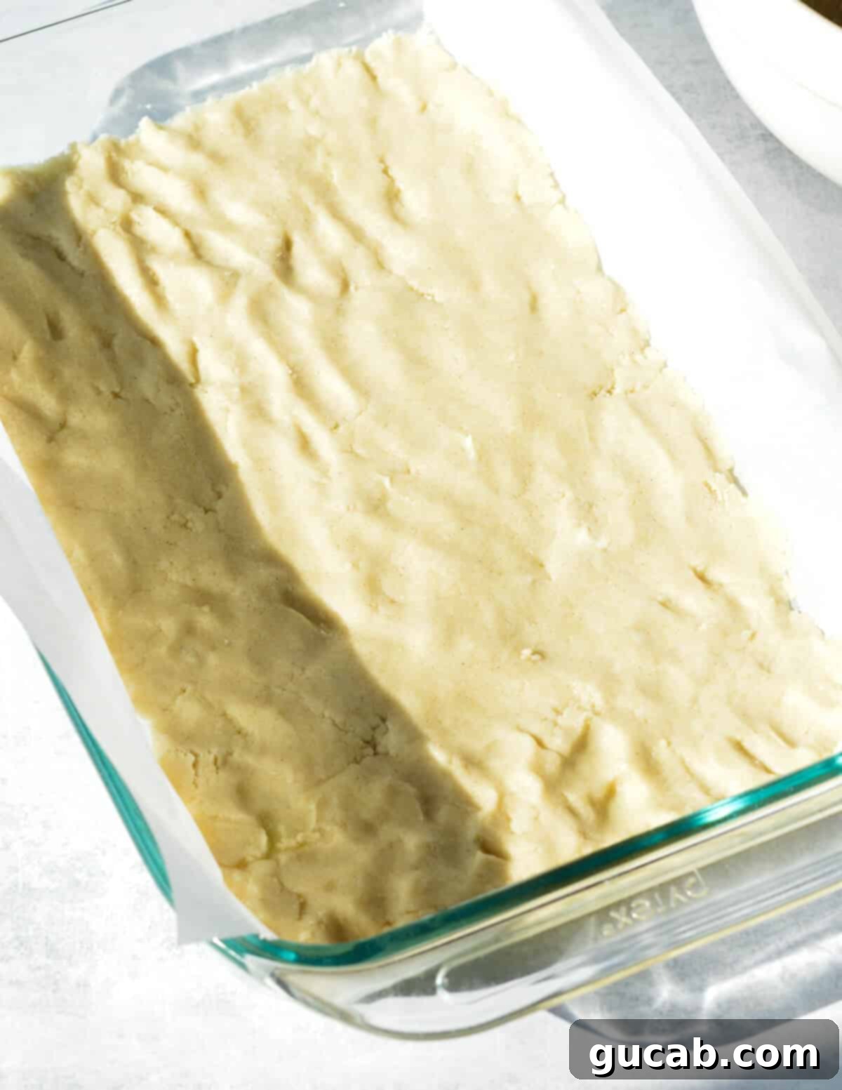 Unbaked gluten-free shortbread crust evenly pressed into a baking dish.