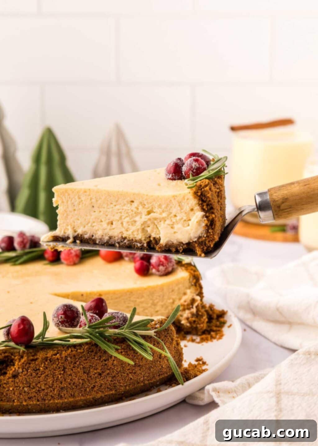 A perfectly sliced piece of eggnog cheesecake, showcasing its creamy texture and festive crumb, on a white plate.
