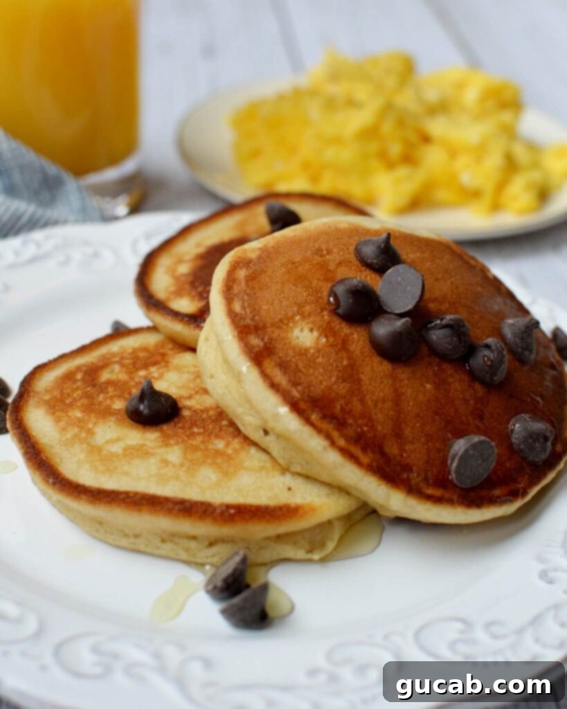 Close-up of fluffy cooked cassava flour pancakes drizzled with maple syrup.