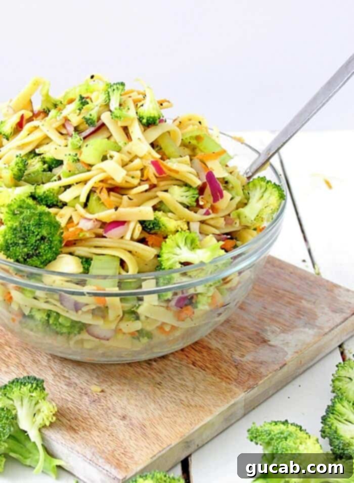 A large bowl of sweet broccoli apple pasta salad, featuring tender pasta, crisp broccoli florets, and sweet apple chunks.