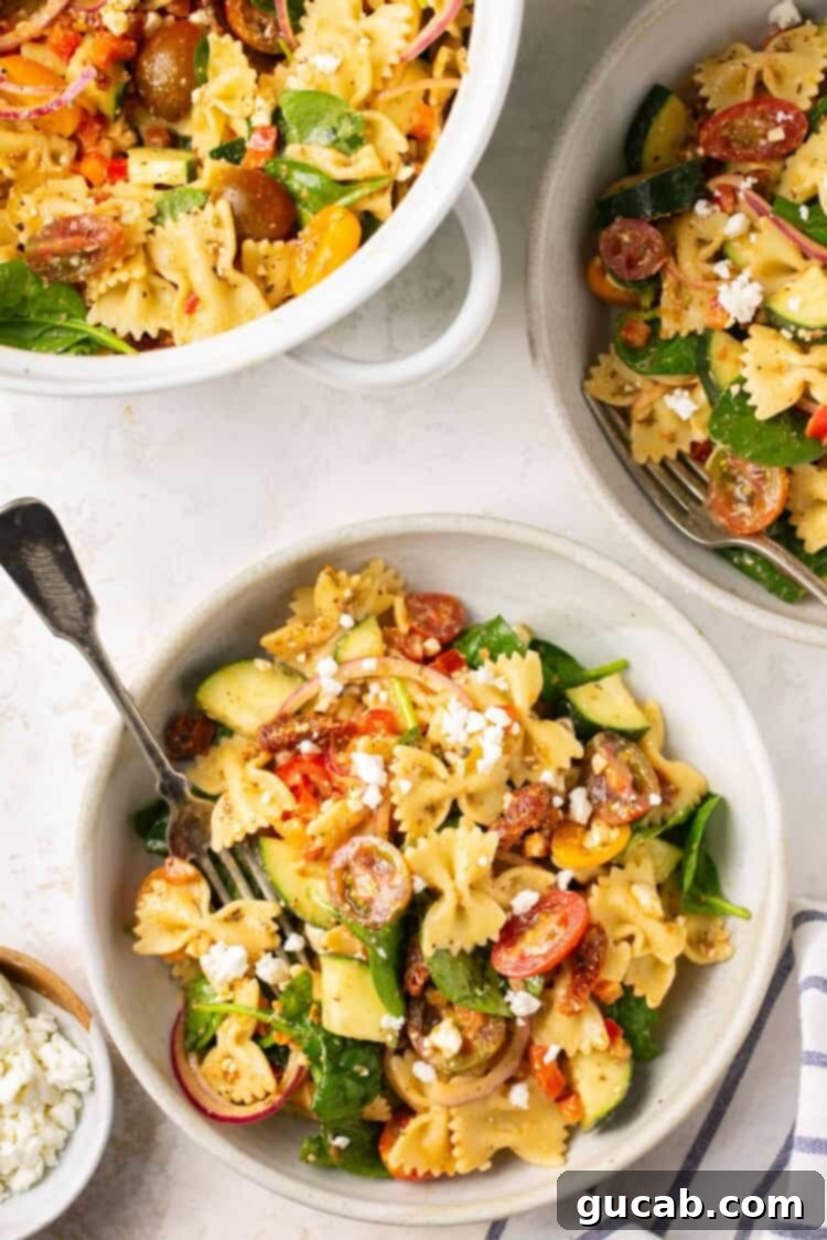 A bowl of vibrant Tuscan pasta salad, showcasing sundried tomatoes, fresh basil, and a creamy dressing.