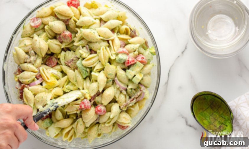 A luscious bowl of green goddess pasta salad, showcasing its creamy, herbaceous dressing and a delightful crunch from bacon bits.