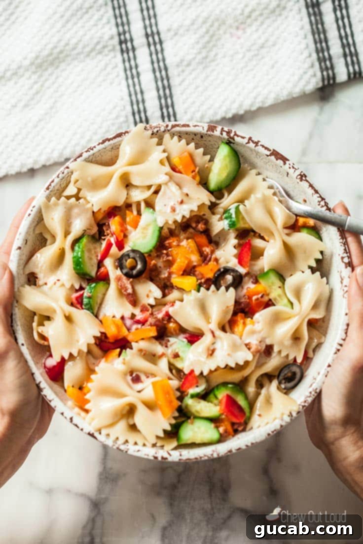 A refreshing bowl of summer Italian pasta salad, featuring pasta, olives, cucumbers, and a zesty Italian dressing.